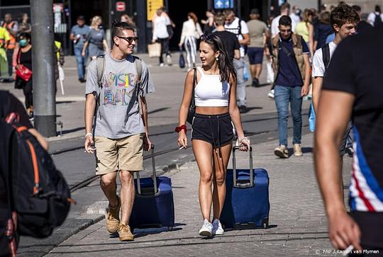 Toeristen op Amsterdam Centraal met koffers